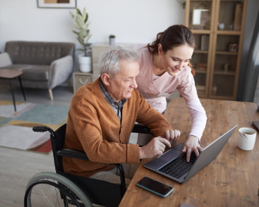 Älteres Herr schaut mit Pflegerin sich Treppenliftangebote an